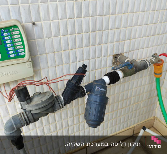 מערכת השקיה עם צינורות ומסנן על קיר